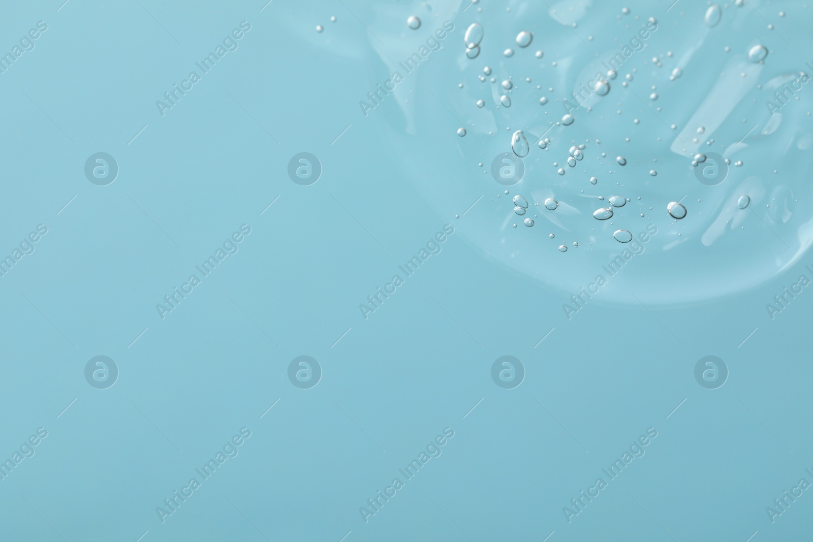 Photo of Sample of cleansing gel on light blue background, top view with space for text. Cosmetic product