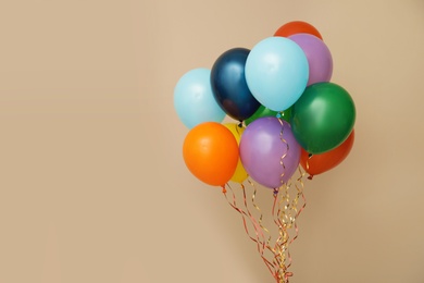 Photo of Bunch of bright balloons on color background, space for text. Celebration time