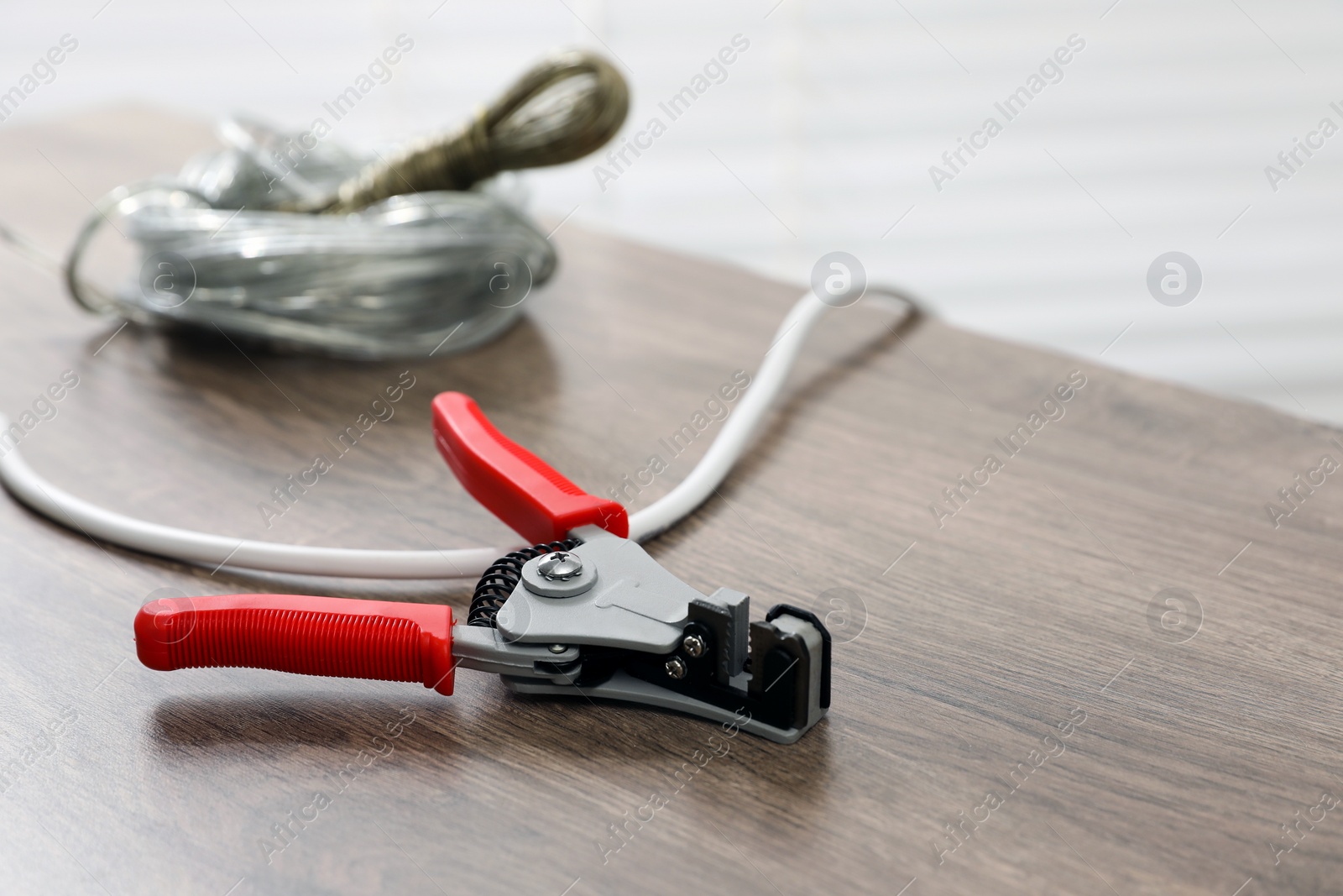 Photo of Cutters and stripped wire on wooden table indoors