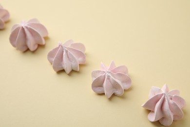 Photo of Delicious meringue cookies on beige background, closeup