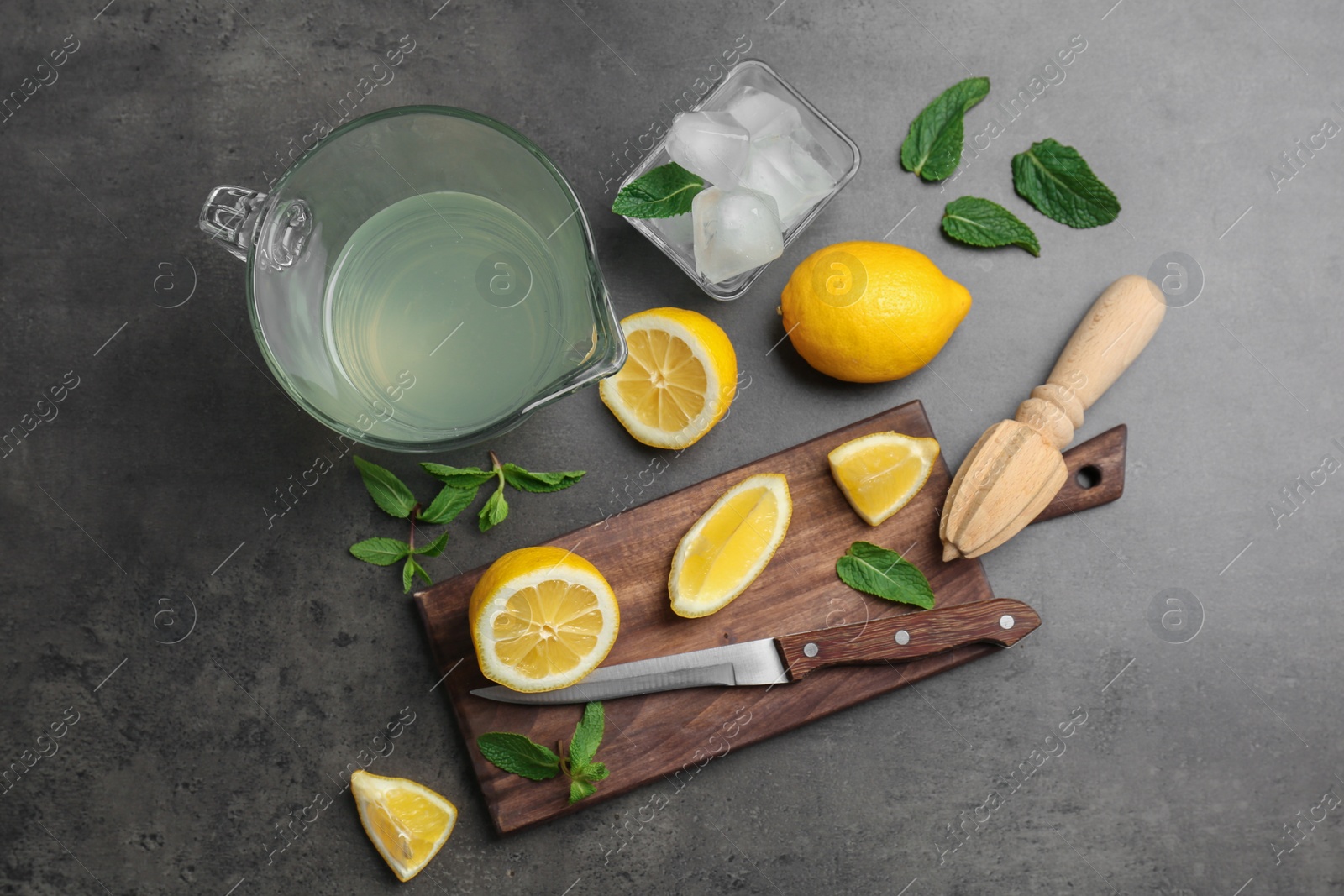 Photo of Flat lay composition with delicious natural lemonade on gray background
