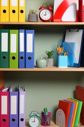 Colorful binder office folders and other stationery on shelving unit