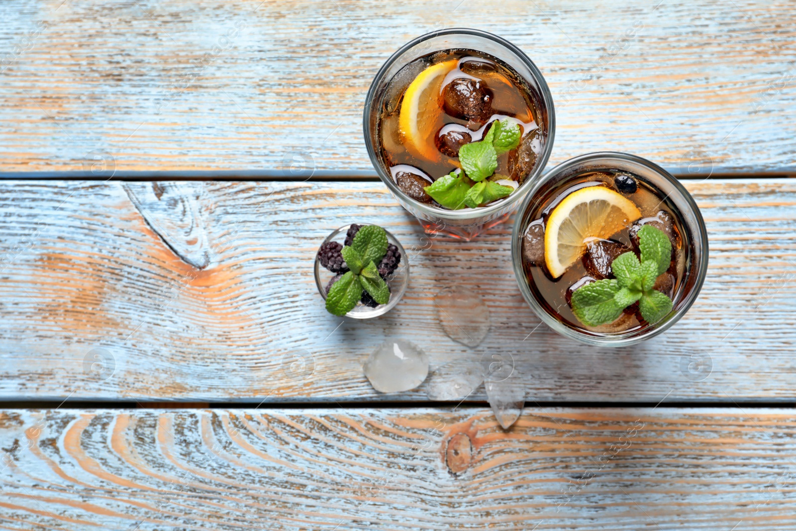 Photo of Glasses of fresh lemonade on wooden table