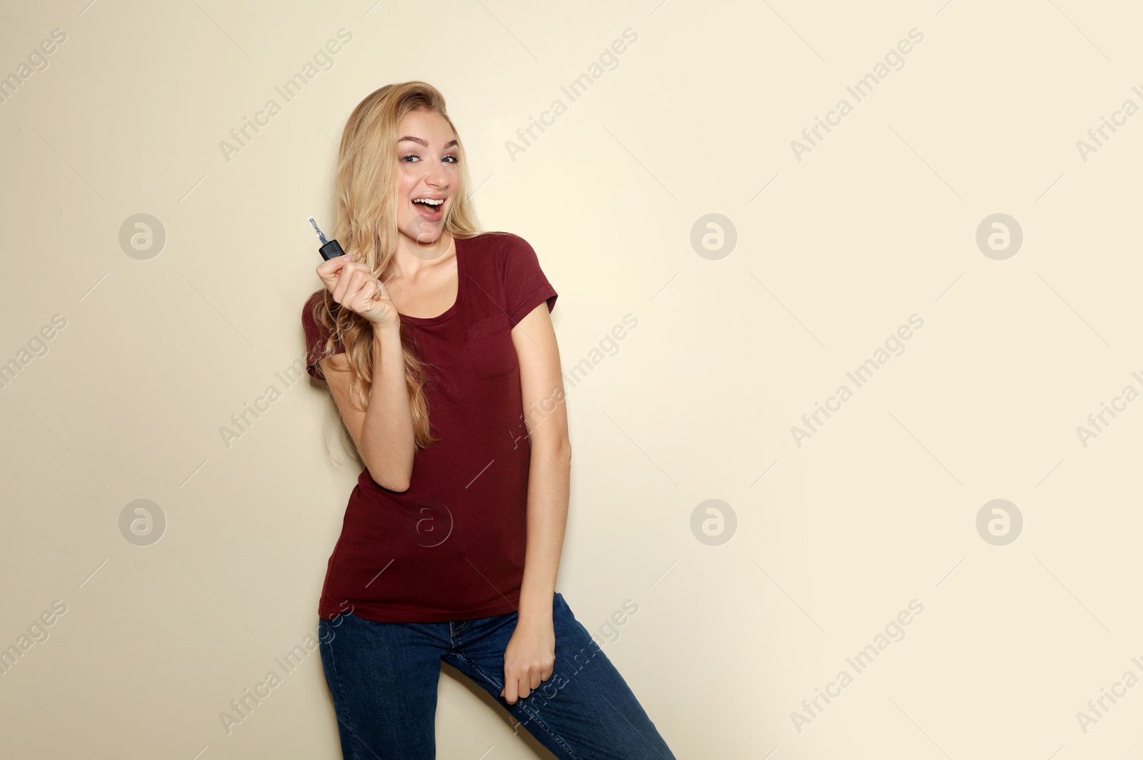 Photo of Happy young woman with car key on color background, space for text. Getting driving license