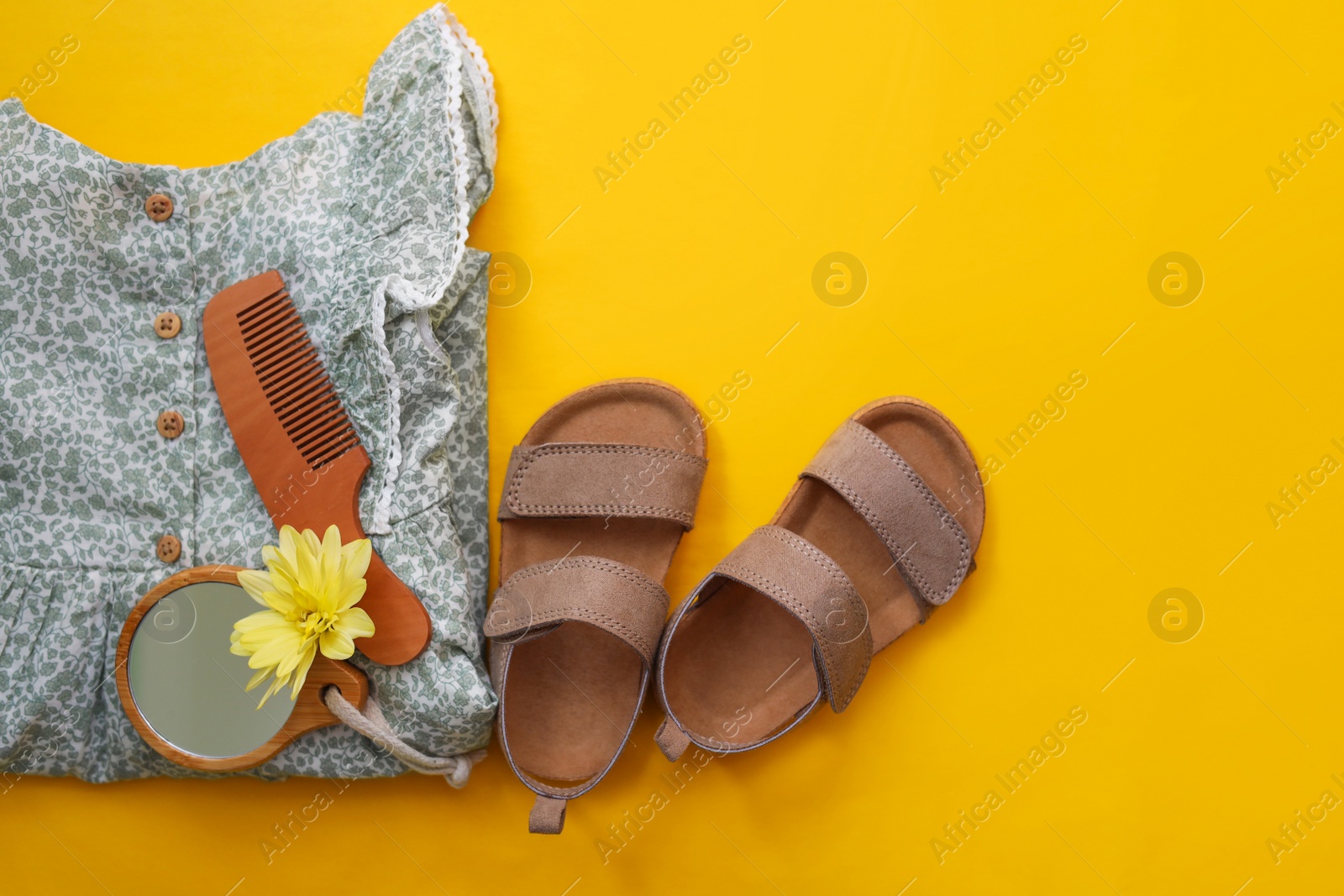 Photo of Stylish child clothes, shoes and accessories on yellow background, flat lay. Space for text