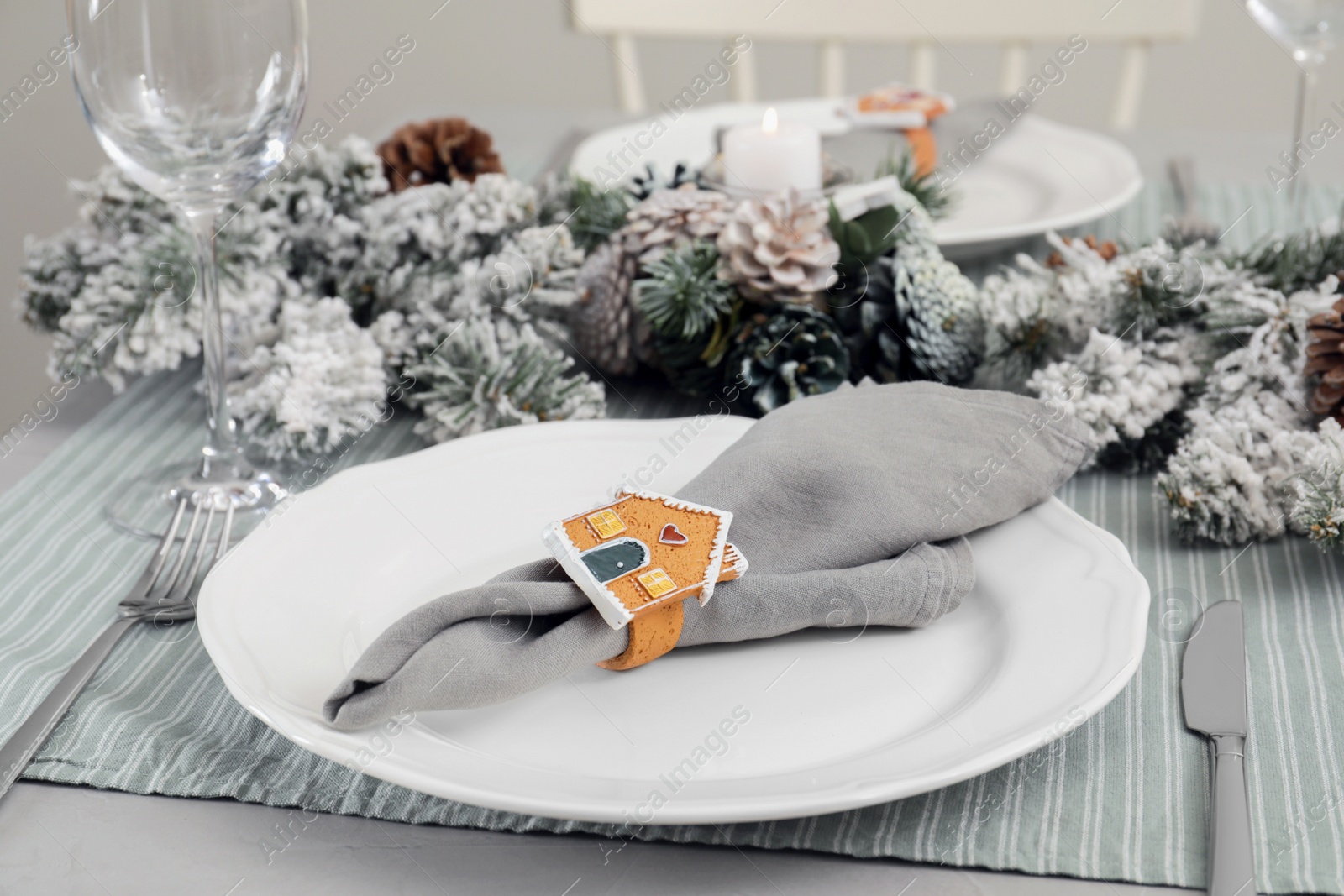 Photo of Festive place setting with beautiful dishware, cutlery and fabric napkin for Christmas dinner on grey table