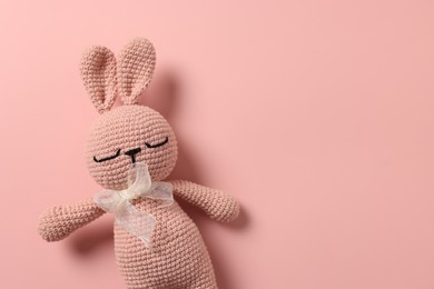 Baby accessory. Toy rabbit on pink background, top view. Space for text