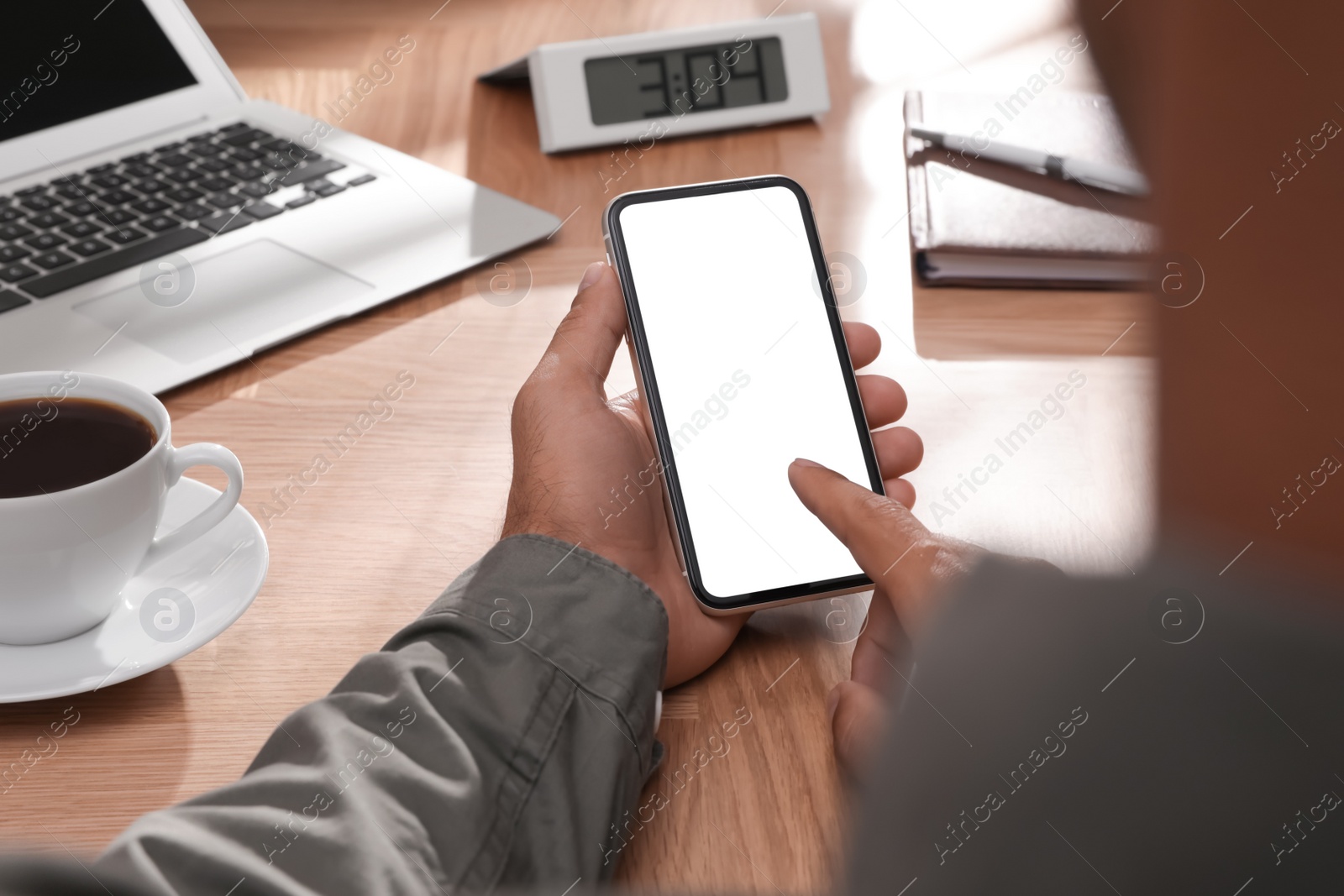 Photo of Man using mobile phone with empty screen at table, closeup