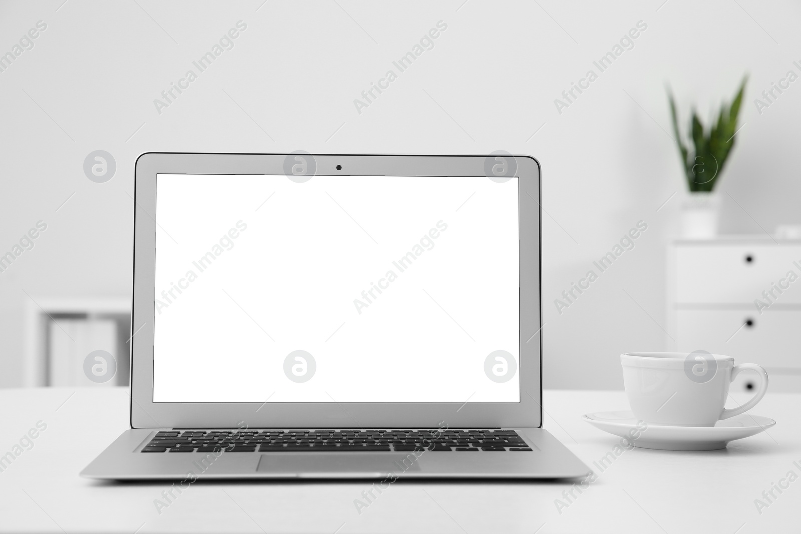 Photo of Comfortable workplace with modern laptop on table in office. Mockup for design