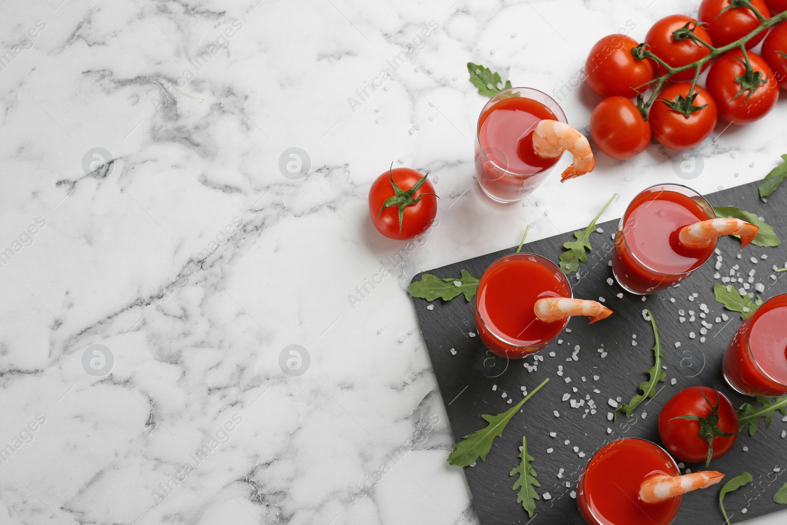 Photo of Shrimp cocktail with tomato sauce served on marble table, flat lay. Space for text