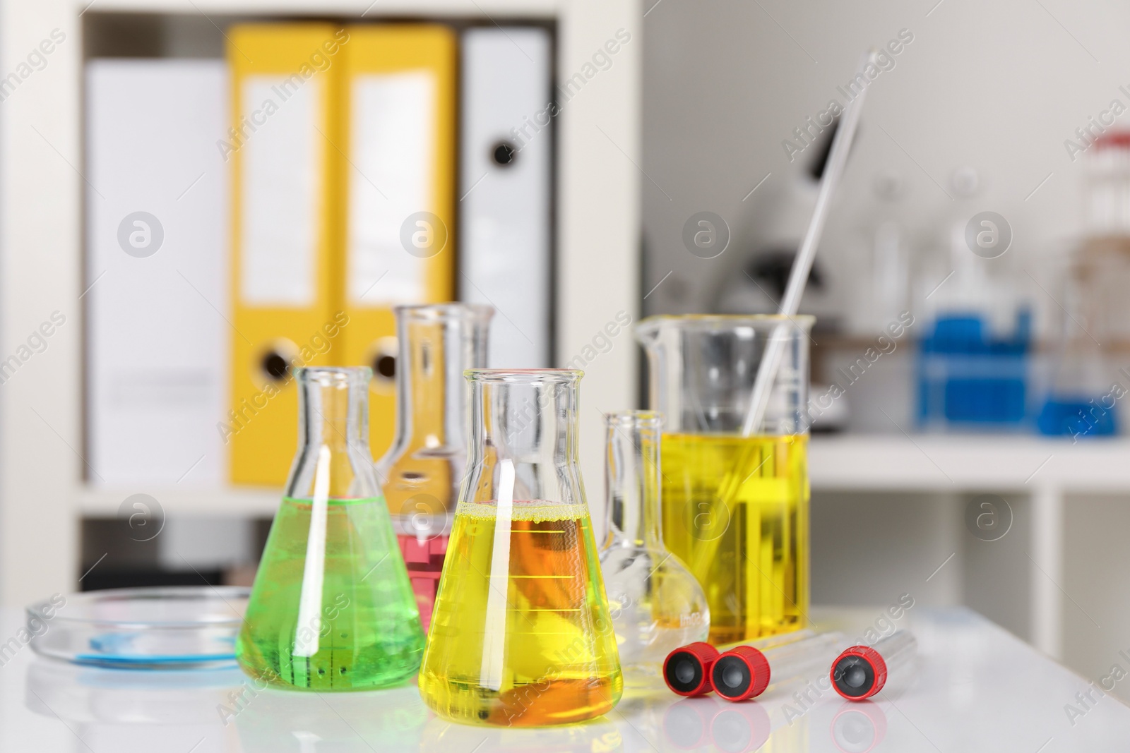 Photo of Laboratory analysis. Different glassware with liquids on white table indoors