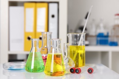 Photo of Laboratory analysis. Different glassware with liquids on white table indoors