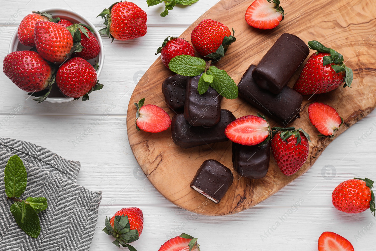 Photo of Delicious glazed curd snacks, mint leaves and fresh strawberries on white wooden table, flat lay