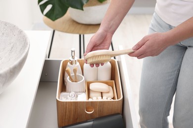 Photo of Bath accessories. Woman organizing personal care products indoors, closeup