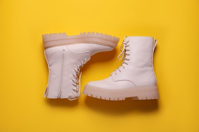 Pair of stylish shoes on yellow background, flat lay