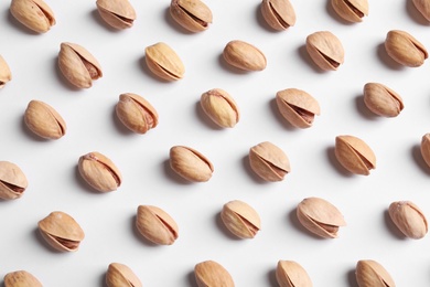 Photo of Organic pistachio nuts on white background, flat lay