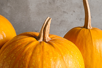 Photo of Ripe pumpkins on grey background, closeup view