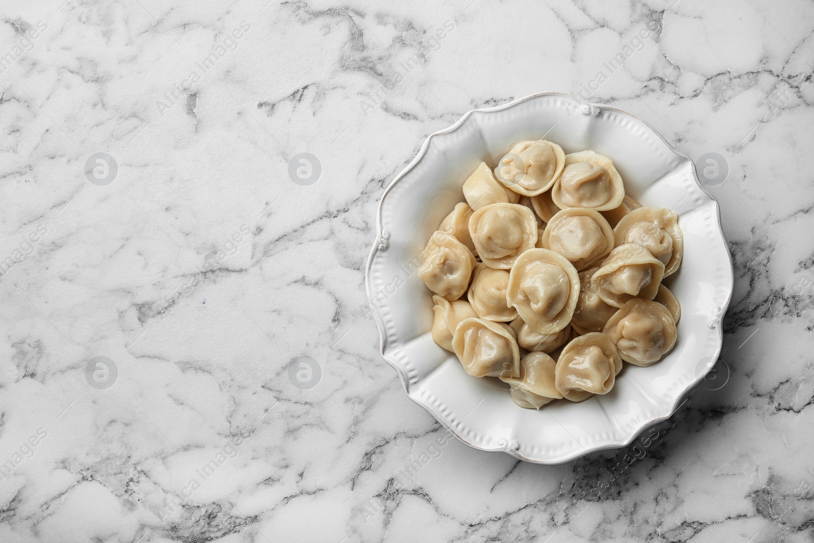 Photo of Tasty dumplings on marble table, top view. Space for text