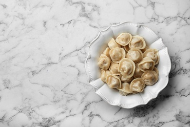 Photo of Tasty dumplings on marble table, top view. Space for text