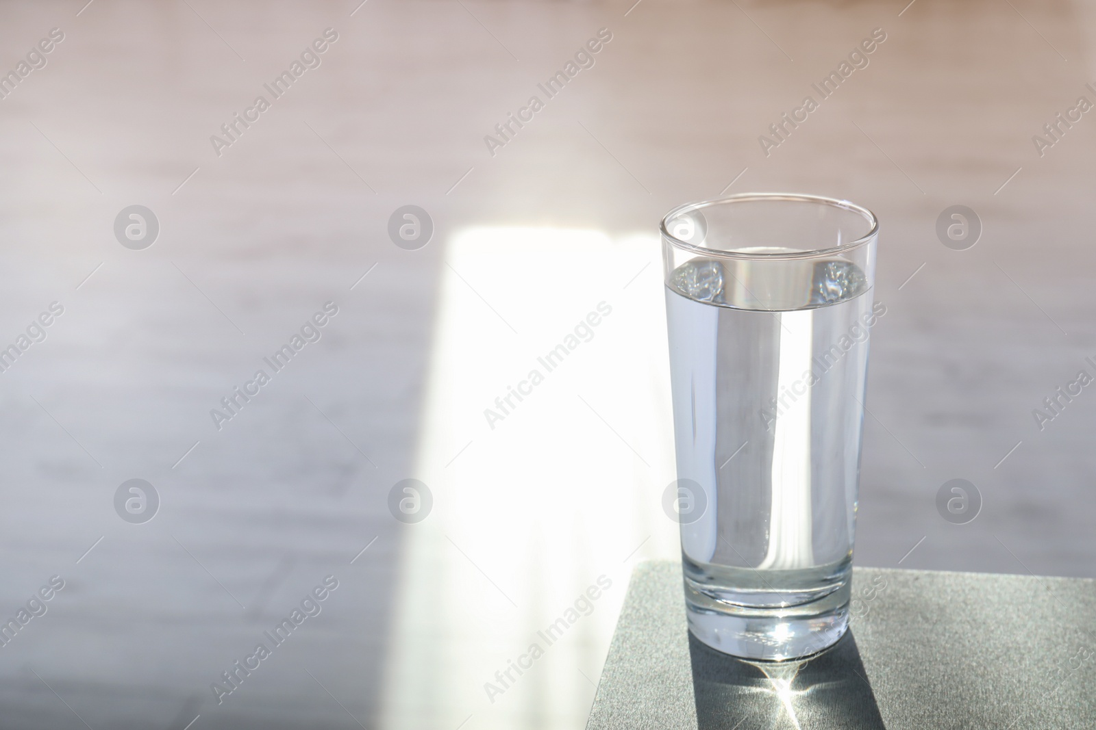 Photo of Glass of pure water on table indoors. Space for text