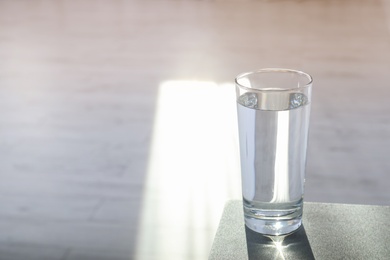 Photo of Glass of pure water on table indoors. Space for text