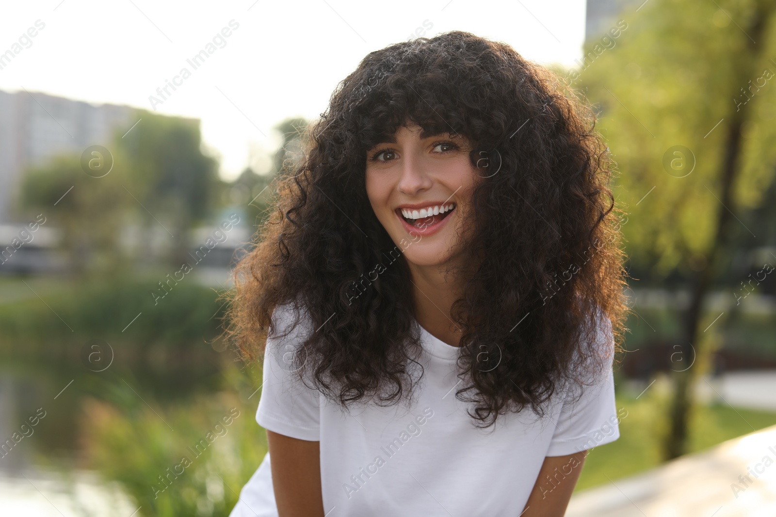 Photo of Portrait of beautiful woman posing outdoors. Attractive lady smiling and looking into camera