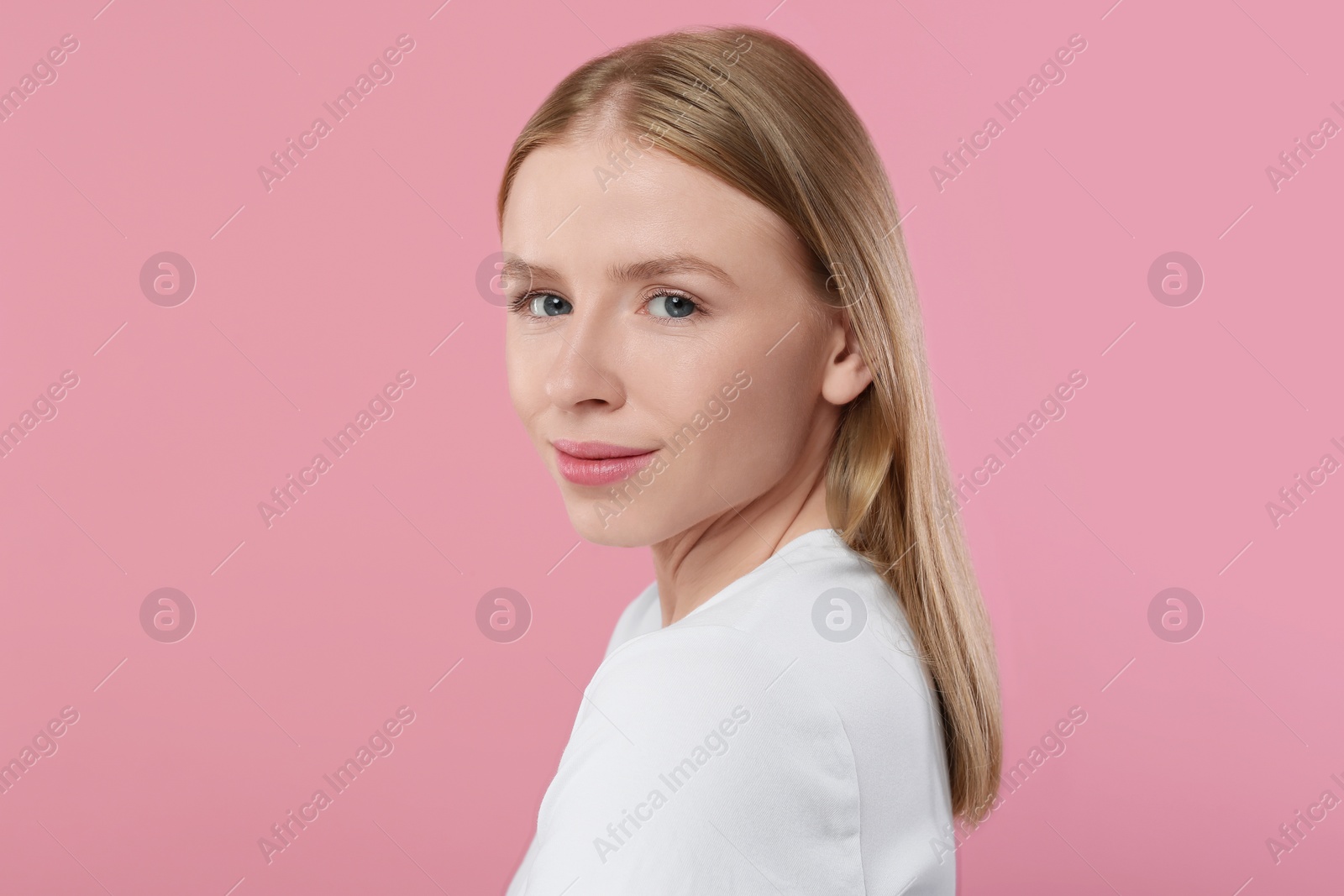 Photo of Portrait of beautiful young woman on pink background