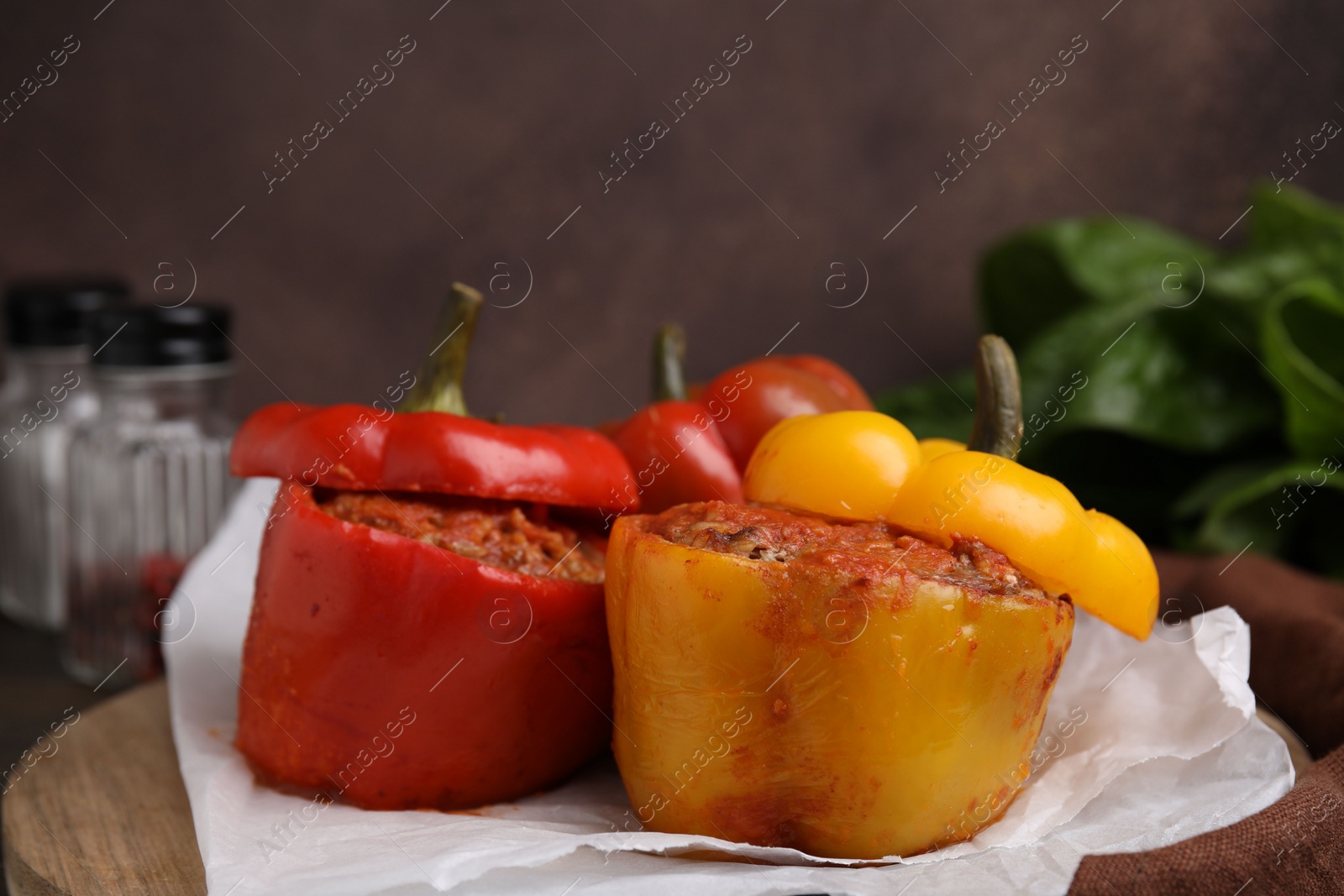 Photo of Delicious stuffed bell peppers served on wooden table, closeup