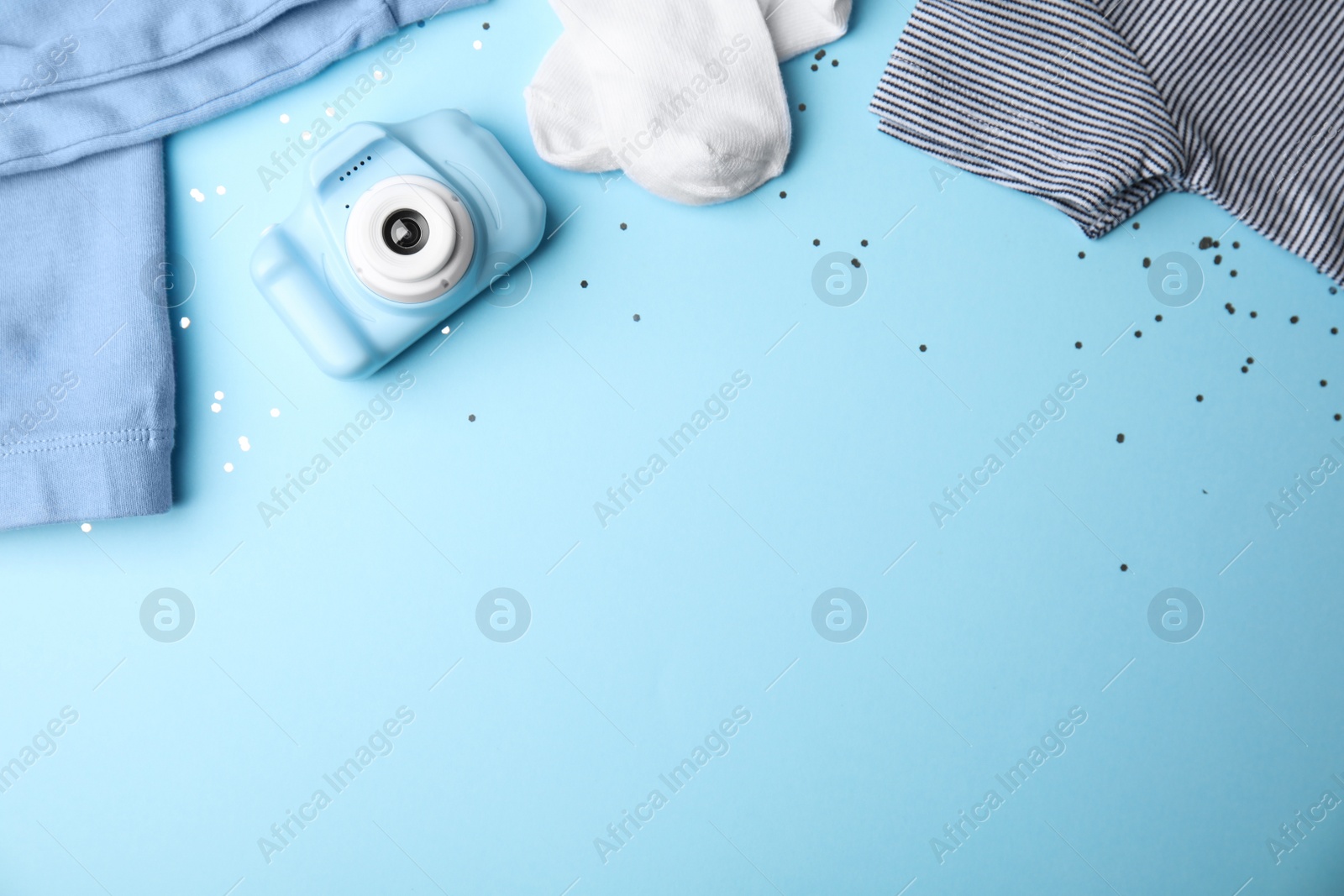 Photo of Flat lay composition with toy camera on light blue background, space for text. Future photographer