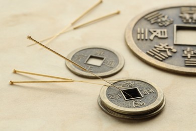 Photo of Acupuncture needles and Chinese coins on paper, closeup