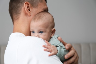 Father holding his cute baby at home