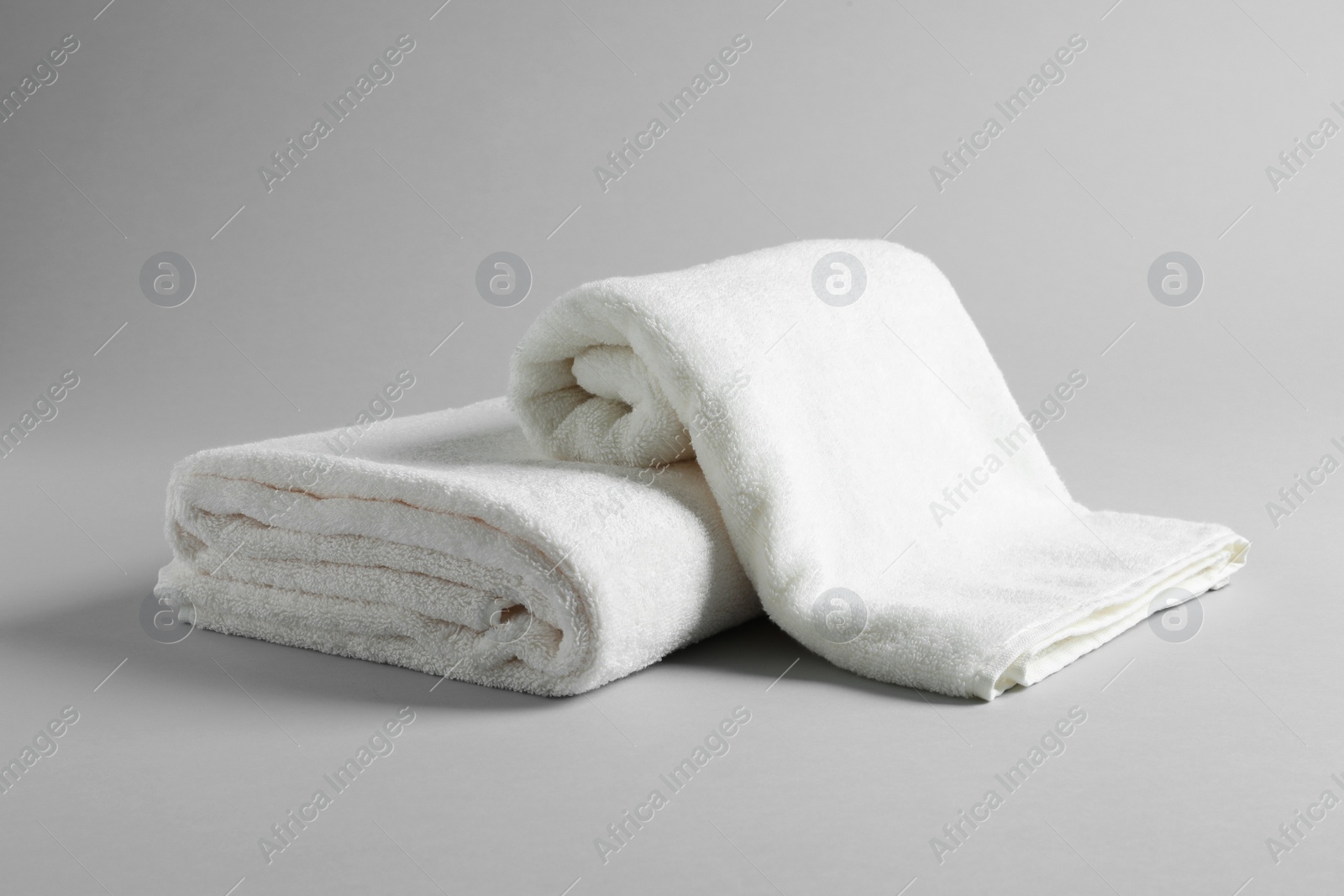 Photo of Fresh soft folded towels on light background