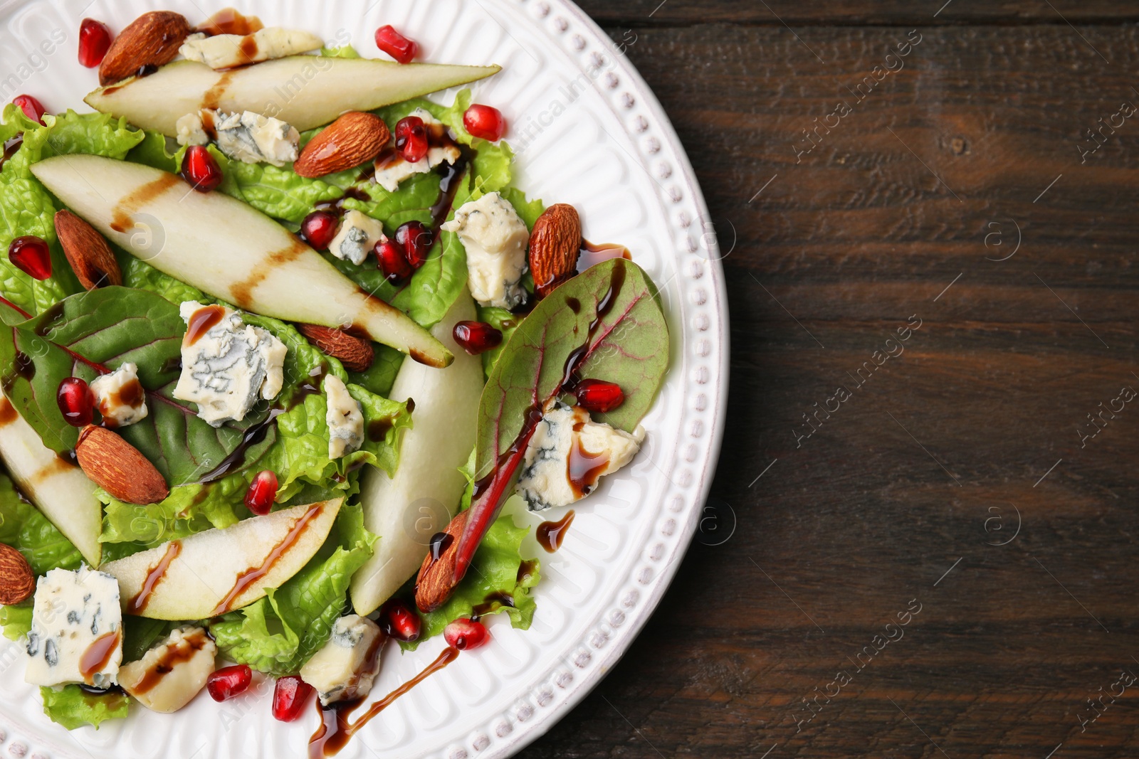 Photo of Delicious pear salad with sauce on wooden table, top view. Space for text