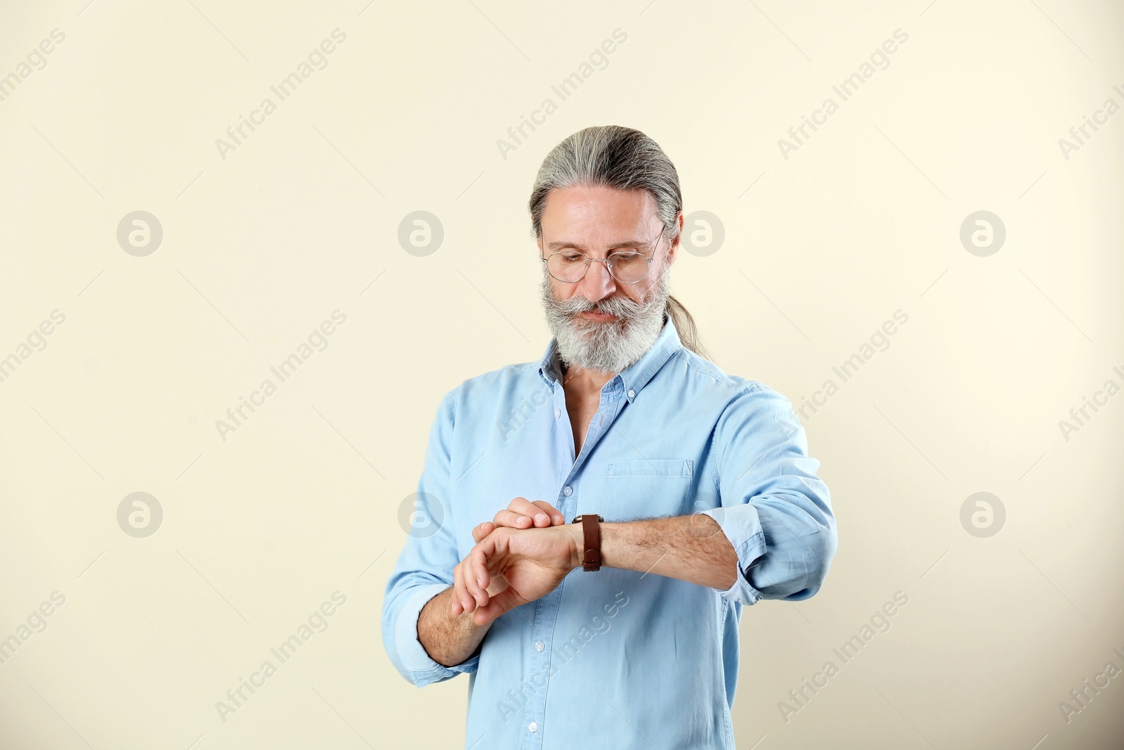 Photo of Handsome bearded mature man on color background