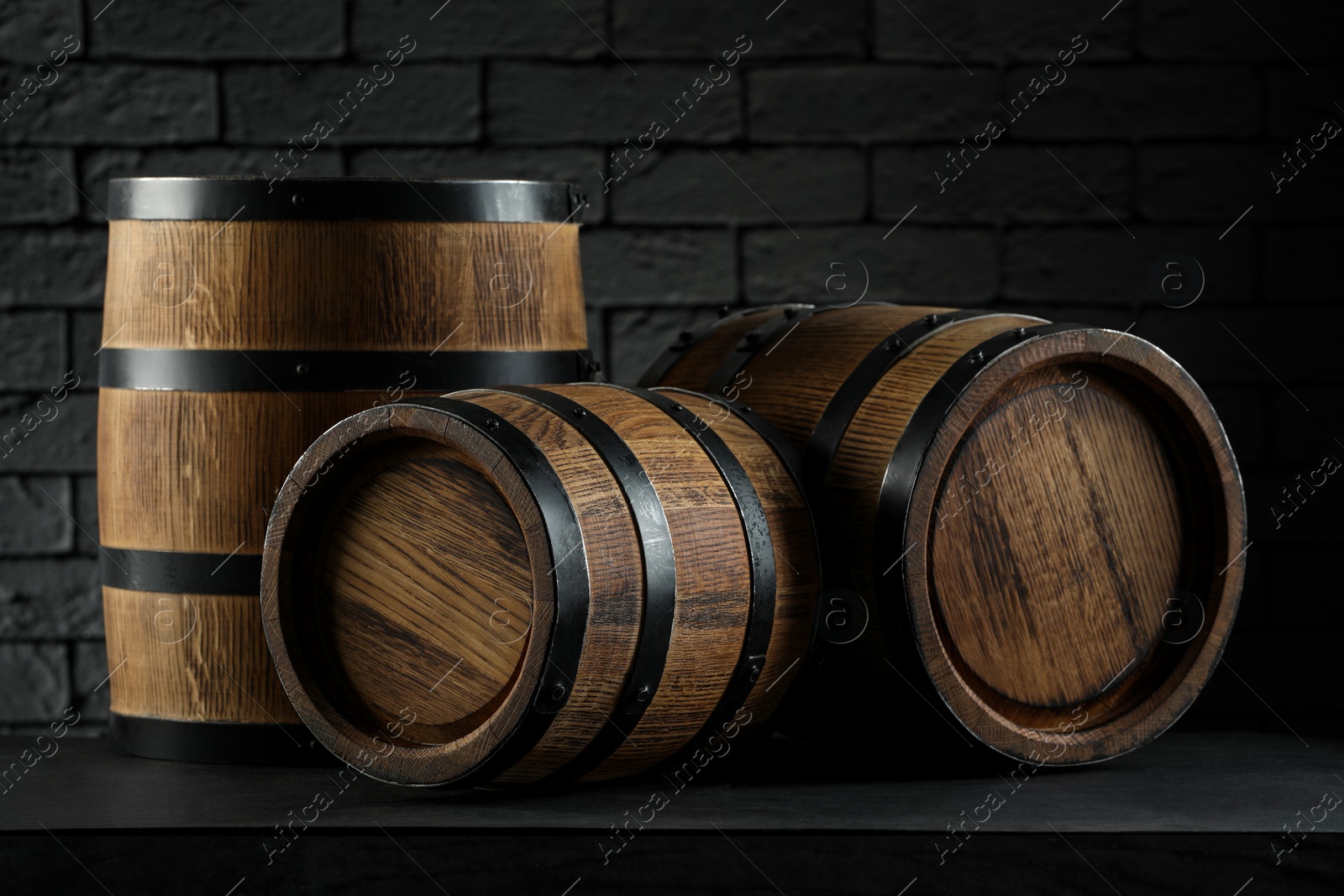 Photo of Wooden barrels on table near brick wall, closeup