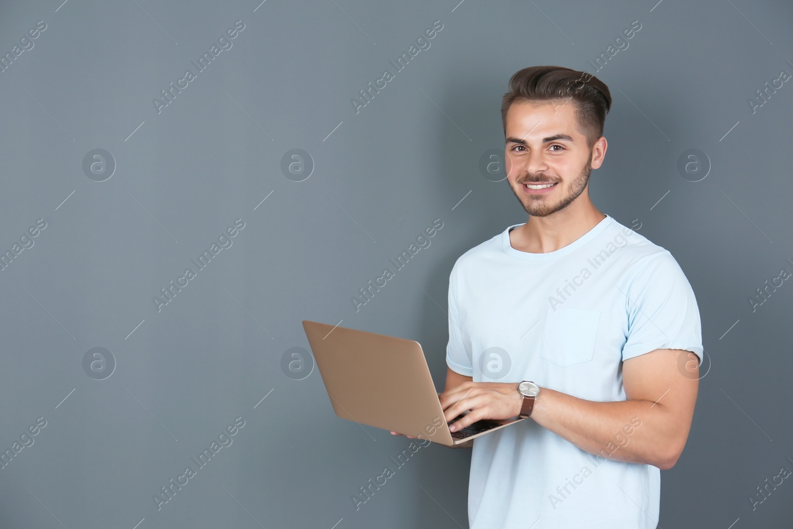 Photo of Man in casual clothes with laptop on color background