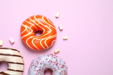 Photo of Delicious glazed donuts on lilac background, flat lay. Space for text