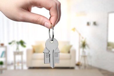 Image of Woman holding house key in room, closeup