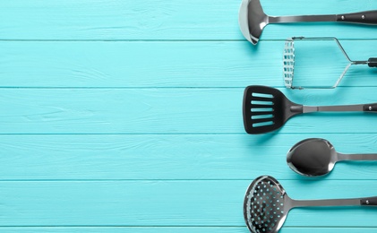 Photo of Set of modern cooking utensils on light blue wooden table, flat lay. Space for text
