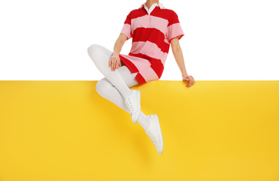 Woman wearing white tights and stylish shoes sitting on color background, closeup