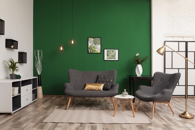 Photo of Modern living room interior stylish sofa near green wall