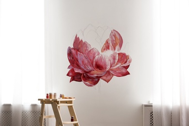 Photo of Unfinished flower painting on white wall in room. Interior design