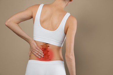Image of Woman suffering from pain in back on beige background, closeup