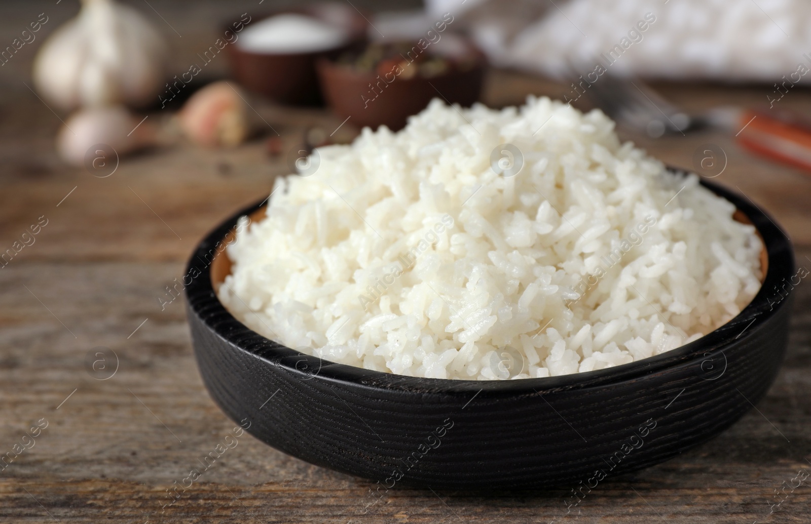 Photo of Boiled rice in bowl on wooden table