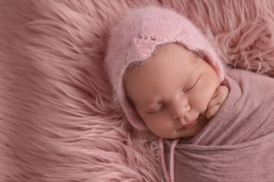Photo of Adorable newborn baby lying on faux fur, top view. Space for text 