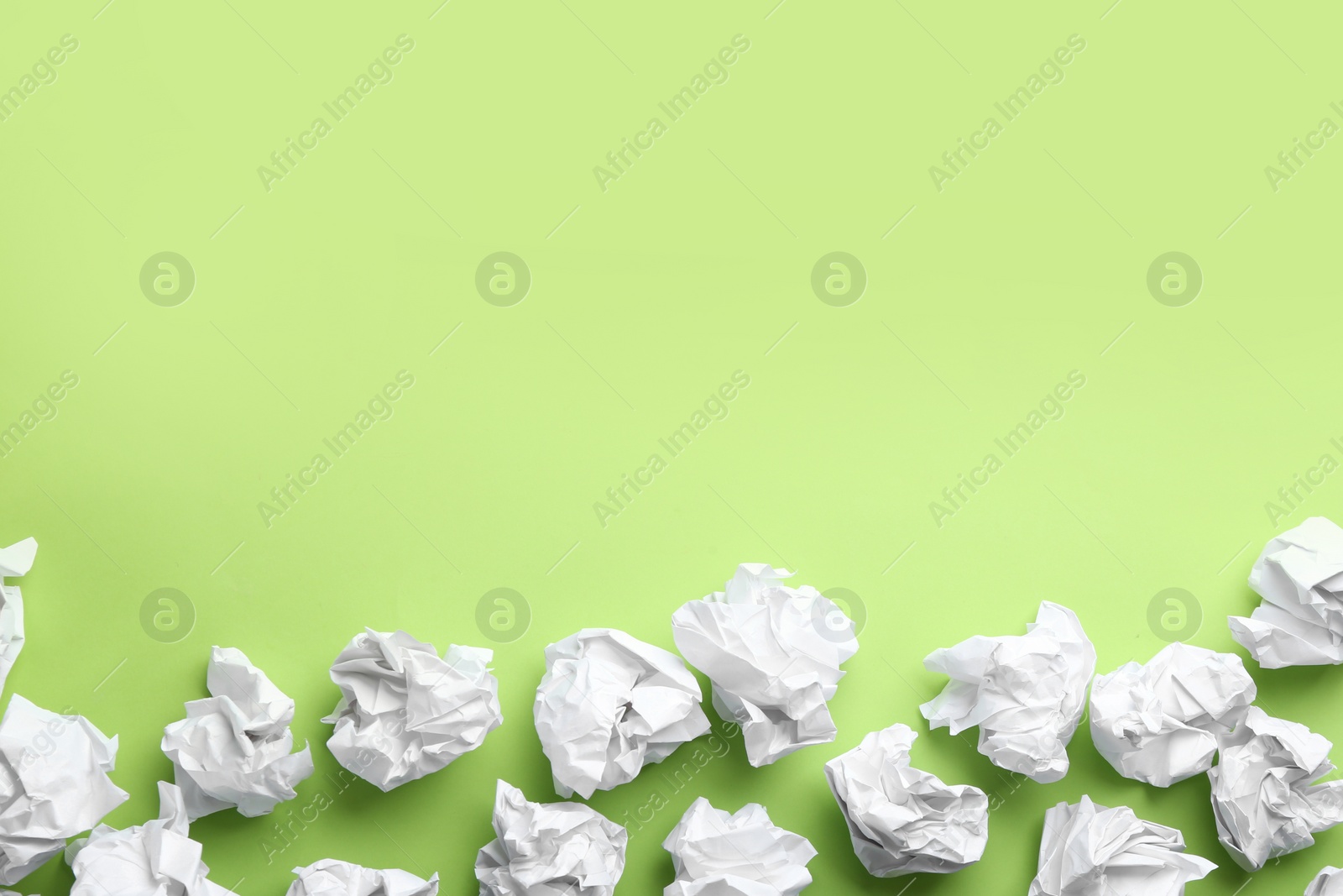 Photo of Crumpled sheets of paper on light green background, flat lay. Space for text