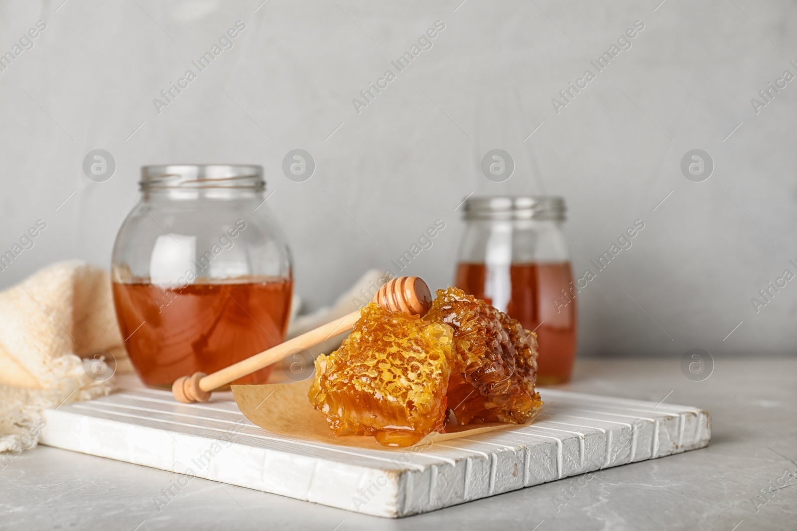 Photo of Composition with tasty honey and combs on gray table