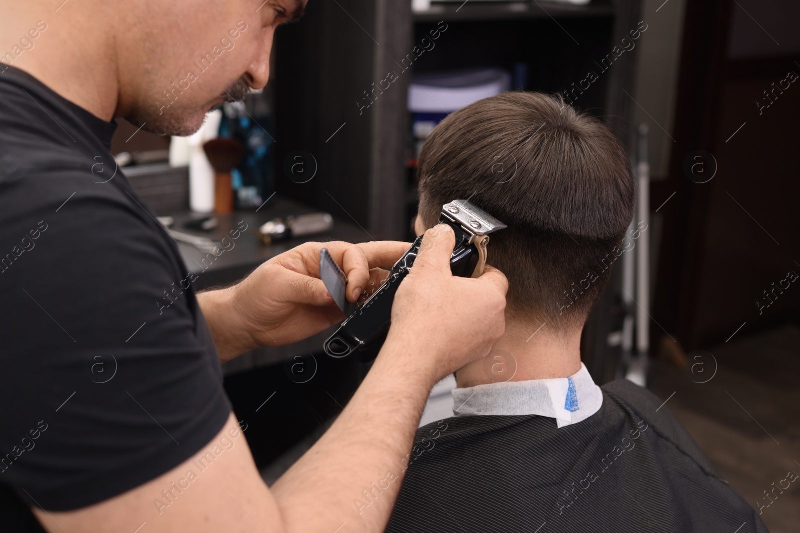 Photo of Professional hairdresser making stylish haircut in barbershop