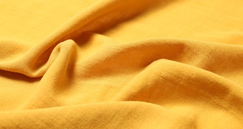 Photo of Texture of soft yellow crumpled fabric as background, closeup