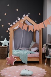 Photo of Stylish child room interior with house bed and different toys